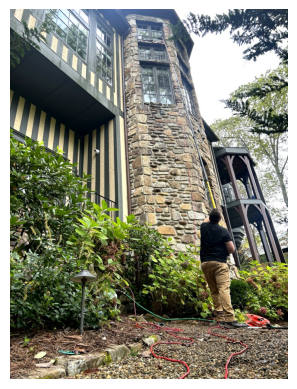 Elite Environment technician cleaning high windows from ground level